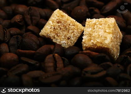 Coffee beans background with two brown sugar cubes. Natural morning light.