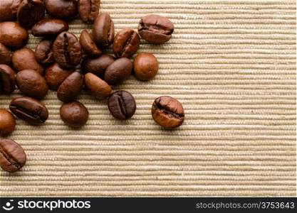 Coffee beans. Backgrounds and textures: dark roasted coffee beans scattered on rough canvas surface