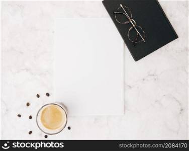 coffee beans coffee glass blank white paper eyeglasses diary marble textured backdrop