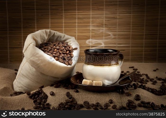 coffee beans, cup with coffee and sack of beans