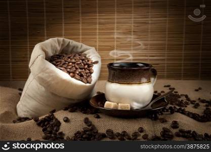 coffee beans, cup with coffee and sack of beans