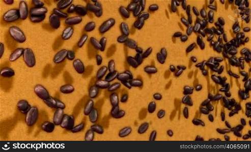Coffee beans falling down over sacking background with slow motion