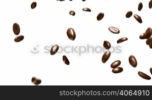 Coffee beans falling down with slow motion over white