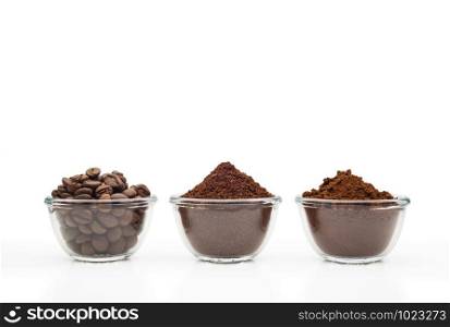 Coffee beans, ground coffee and instant coffee, in little glass cups on a clean white background