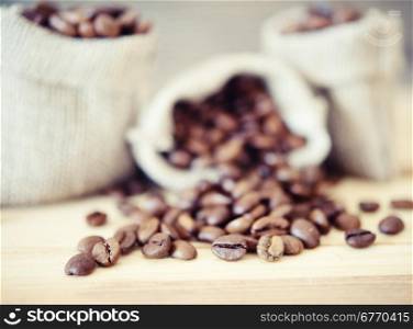 coffee beans in a burlap sack on wooden background