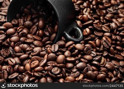 Coffee beans in a coffee cup on freshly roasted coffee beans. Texture of coffee ready to drink, selective focus