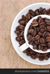 coffee beans in a cup on a wooden background