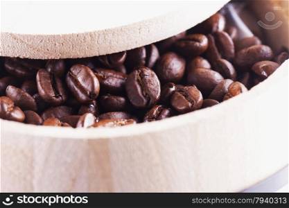 Coffee beans in a wooden barrel, close up, horizontal image