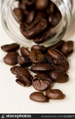 Coffee beans in and out of a jar of glass.