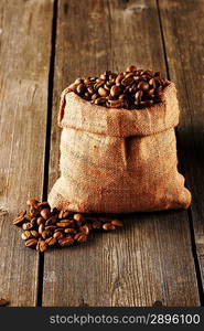 Coffee beans in bag on wooden table