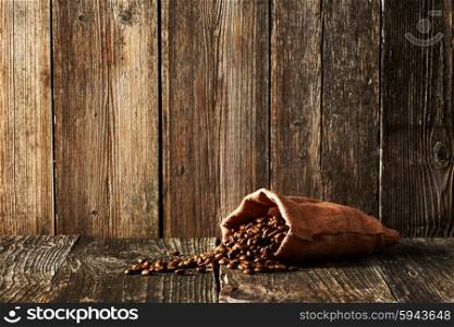 Coffee beans in sack on wooden table