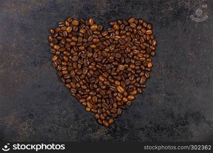 Coffee beans in shape of heart on dark rustic background. Coffee beans in shape of heart, flat lay, top view