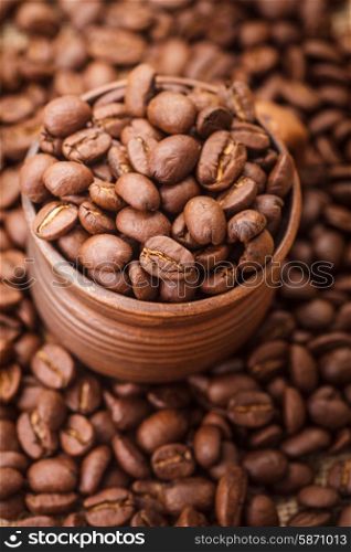 Coffee beans in the clay cup close up