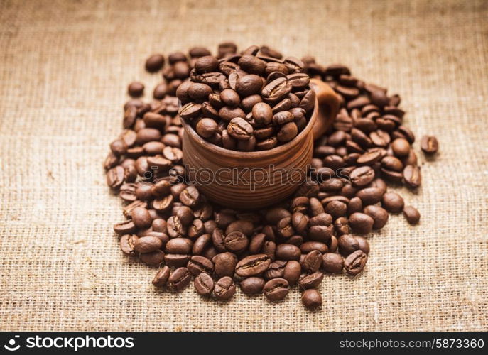 Coffee beans in the clay cup close up