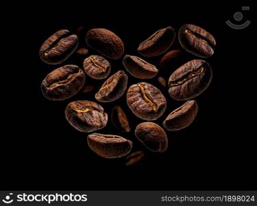 Coffee beans in the shape of a heart on a black background.. Coffee beans in the shape of a heart on a black background