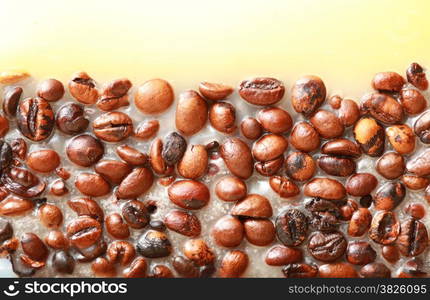 Coffee beans in yellow wax as background with space for text