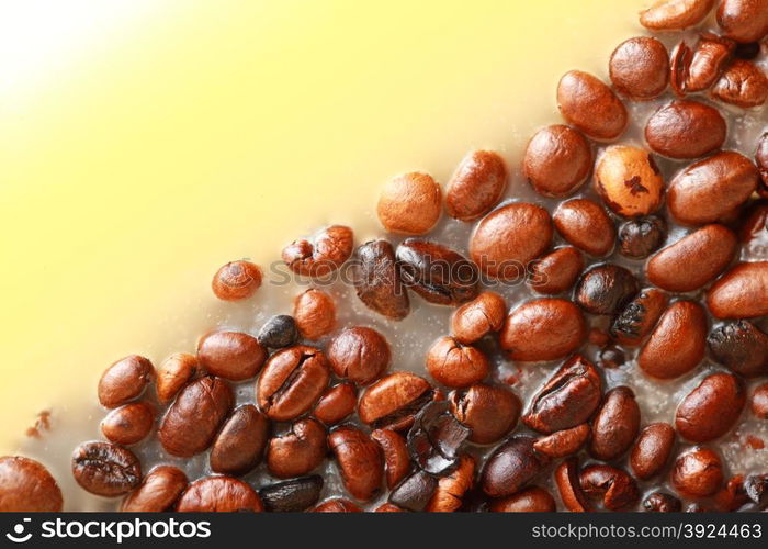 Coffee beans in yellow wax as background with space for text