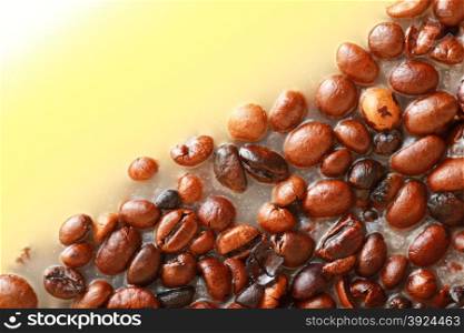 Coffee beans in yellow wax as background with space for text