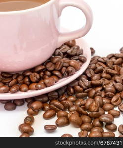 Coffee beans next to a cup of new freshly brewed