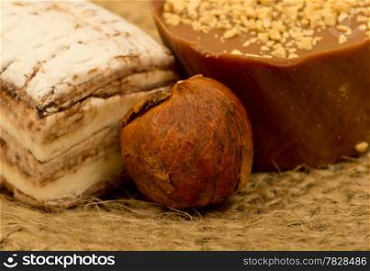 coffee beans, nuts and sweet on burlap background, focused on nuts