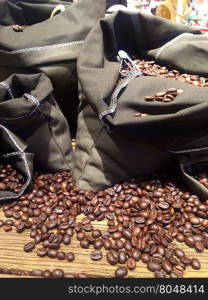 coffee beans on bags over rustic wood background