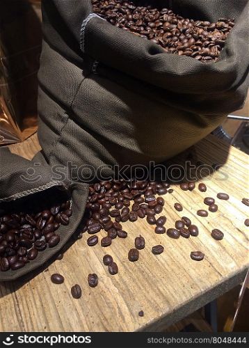 coffee beans on bags over rustic wood background