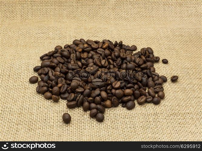 Coffee beans on burlap background.