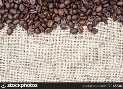 Coffee beans on hessian background as a border