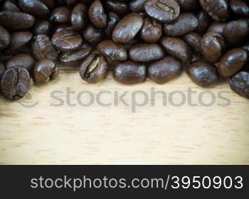 Coffee beans on wood background with copy space&#xA;