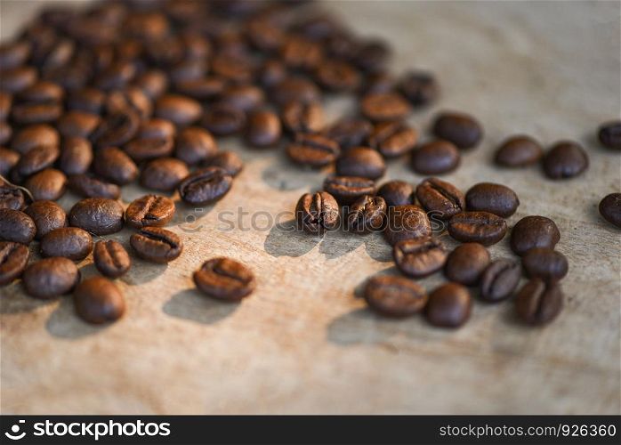 Coffee beans roasted on rustic wood background - selective focus