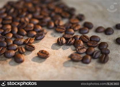 Coffee beans roasted on rustic wood background - selective focus