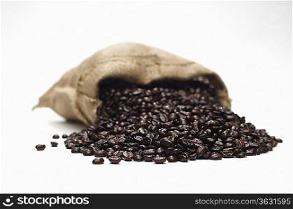 Coffee beans spilling from sack, close-up