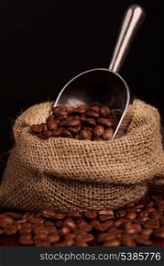 coffee beans spilling out of steel scoop