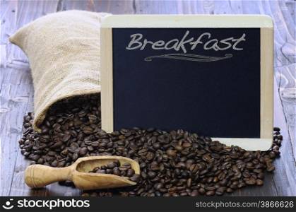 Coffee beans with blackboard on a wooden table.