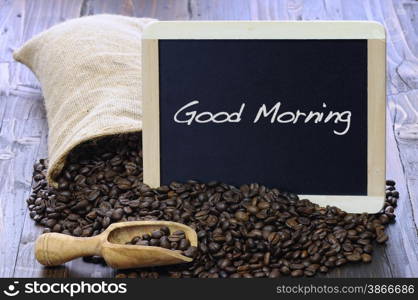 Coffee beans with blackboard on a wooden table.