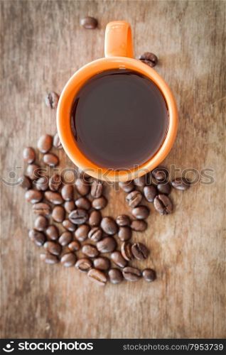 Coffee beans with coffee cup on wooden table, stock photo