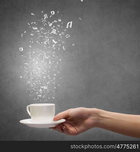 Coffee break. Close up of hand holding white cup of tea or coffee