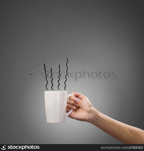 Coffee break. Close up of hand holding white mug of tea or coffee