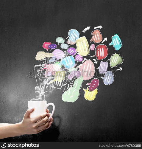 Coffee break. Close up of hand holding white mug of tea or coffee