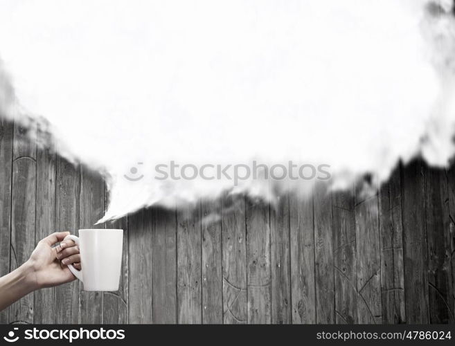 Coffee break. Close up of hand holding white mug of tea or coffee