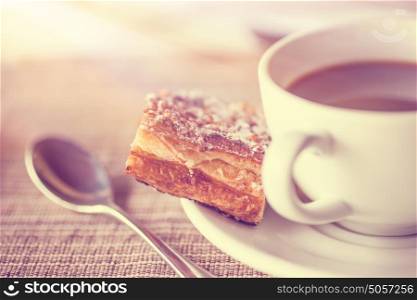 Coffee break, vintage style photo of a coffee cup with small tasty piece of pie, delicious dessert in the cafe