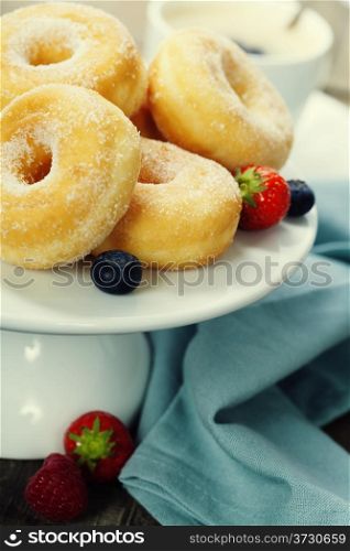 Coffee break with fresh berries and sugary donuts over white background