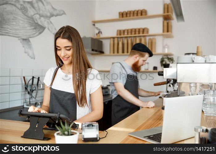 Coffee Business Concept - beautiful caucasian bartender barista or manager Posting order in digital tablet menu at modern coffee shop.