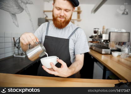 Coffee Business Concept - handsome bearded man in apron making coffee while standing at cafe
