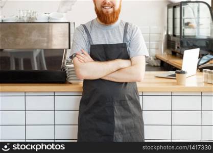 Coffee Business owner Concept - Portrait of happy young bearded caucasian barista in apron with confident looking and smiling to camera in coffee shop counter.
