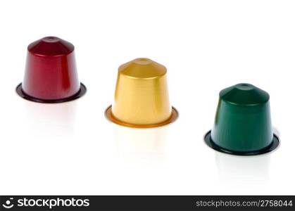 Coffee capsules for a coffee machine, close up view on white reflective background.