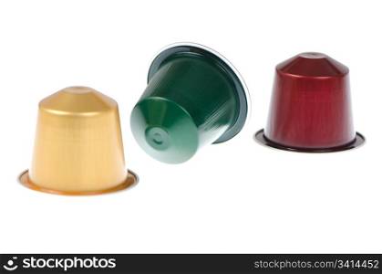 Coffee capsules for a coffee machine, close up view on white reflective background.