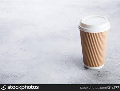 Coffee cardboard cup for take away or coffee to go on stone kitchen background. Brown color. Space for text.