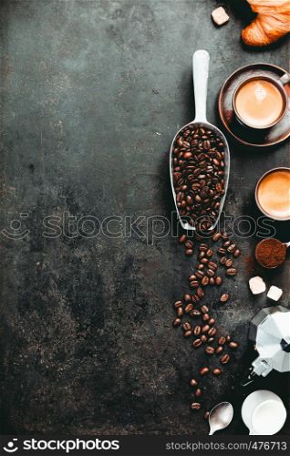 Coffee composition on dark background. Coffee espresso in dark cups, coffee beant, ground coffee, brown sugar, milk, croissants, capsules. Food frame concept. Flat lay. Coffee espresso in dark cups, coffee beant, ground coffee, brown sugar, milk, croissants, capsules.