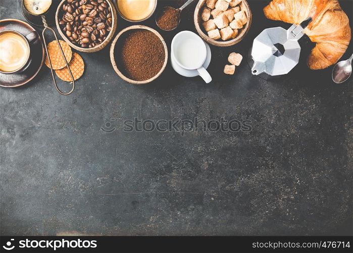 Coffee composition on dark background. Coffee espresso in dark cups, coffee beant, ground coffee, brown sugar, milk, croissants, capsules. Food frame concept. Flat lay. Coffee composition on dark background. flat lay